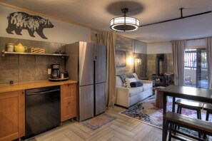 A compact kitchen with a refrigerator, coffee maker, and wooden cabinets.