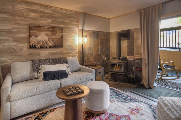 A cozy living room with a fireplace, a sofa, a coffee table, and a rug.