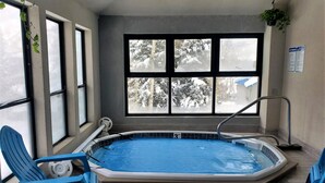 A small indoor swimming pool with a view of snowy trees through large windows. - Cozy Bear Den (#109) | Close to Lifts, Fireplace, Patio, No Stairs, Hot Tub (Durango)