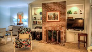 Ein Wohnzimmer mit Kamin, Fernseher und Bücherregal.