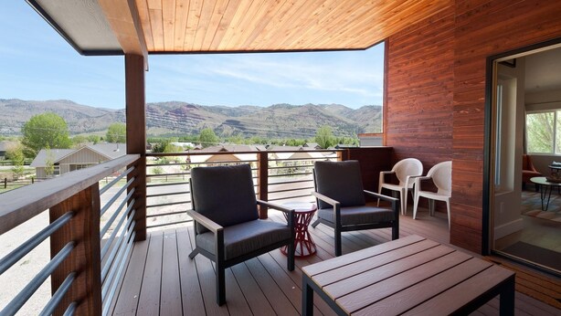 A wooden deck with outdoor seating, a view of mountains, and a glass door leading to an interior space. - Mountain Home w/Amazing Views - 12 Min. to Durango - Central AC - EV Charger (Durango)
