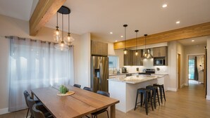 A modern kitchen with a central island, stainless steel appliances, and pendant lighting. - Mountain Home w/Amazing Views - 12 Min. to Durango - Central AC - EV Charger (Durango)