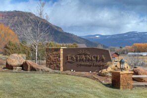 A sign for Estancia Animas Valley with a mountainous backdrop.