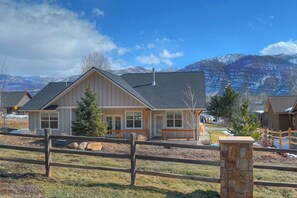 A two-story house with a front porch, a stone pillar, and a view of snow-capped mountains in the background. - New Contemporary Mountain Home - 12 Min. to Durango - Central AC - Views (Durango)