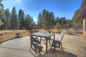Relax in a serene outdoor space surrounded by nature, with a patio featuring a table and chairs.