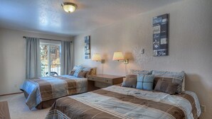 Een slaapkamer met twee bedden, een raam met gordijnen, een nachtkastje en wandlampen.