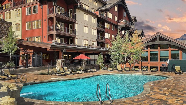 Un hôtel doté d'une piscine, d'un espace extérieur aménagé et offrant une vue sur la montagne.