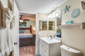 Un bagno con un mobile lavabo bianco, uno specchio grande e un water. Si nota una rastrelliera per asciugamani e una stella marina decorativa sulla parete.