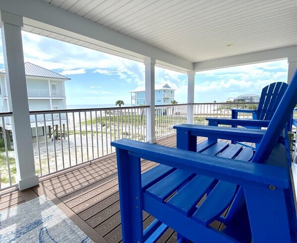 Relax on the deck overlooking the sandy beach and enjoy the serene views.