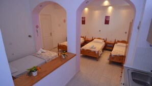 A compact room with two single beds, a small kitchenette, and a bathroom. - Marianthi Studios Stegna (Rhodes)