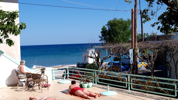 A terrace with a view of the sea, outdoor furniture, and potted plants. - Marianthi Studios Stegna (Rhodes)