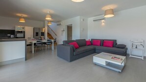 A modern living room with a grey sofa, red cushions, a white coffee table, and pendant lights. - Villa Stefanja in Galizana (Galizana)