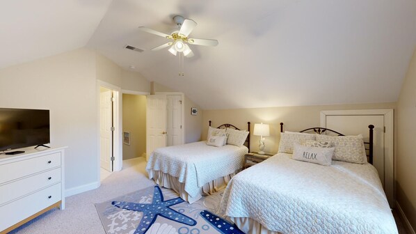 A bedroom with two beds, a ceiling fan, a TV, and a starfish rug. - Large four Bedroom Four Bathroom Home on Robert Trent Jones Golf Course! (Hilton Head)