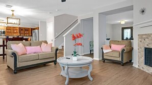 Un salon spacieux avec deux canapés, une table basse et une cheminée.