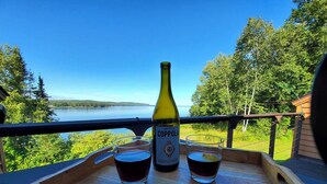 En flaska Coppola-vin och två glas på ett träbricka, med utsikt över en vacker sjö.