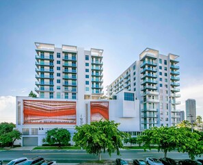 Experience contemporary living in a high-rise apartment with a unique facade and balcony.