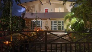 A two-story house with a balcony, a garage, and a well-lit entrance. - Exclusive and spacious house in Guaynabo (Guaynabo)