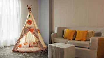 Relax in a spacious living area with a sofa, ottoman, and decorative teepee.