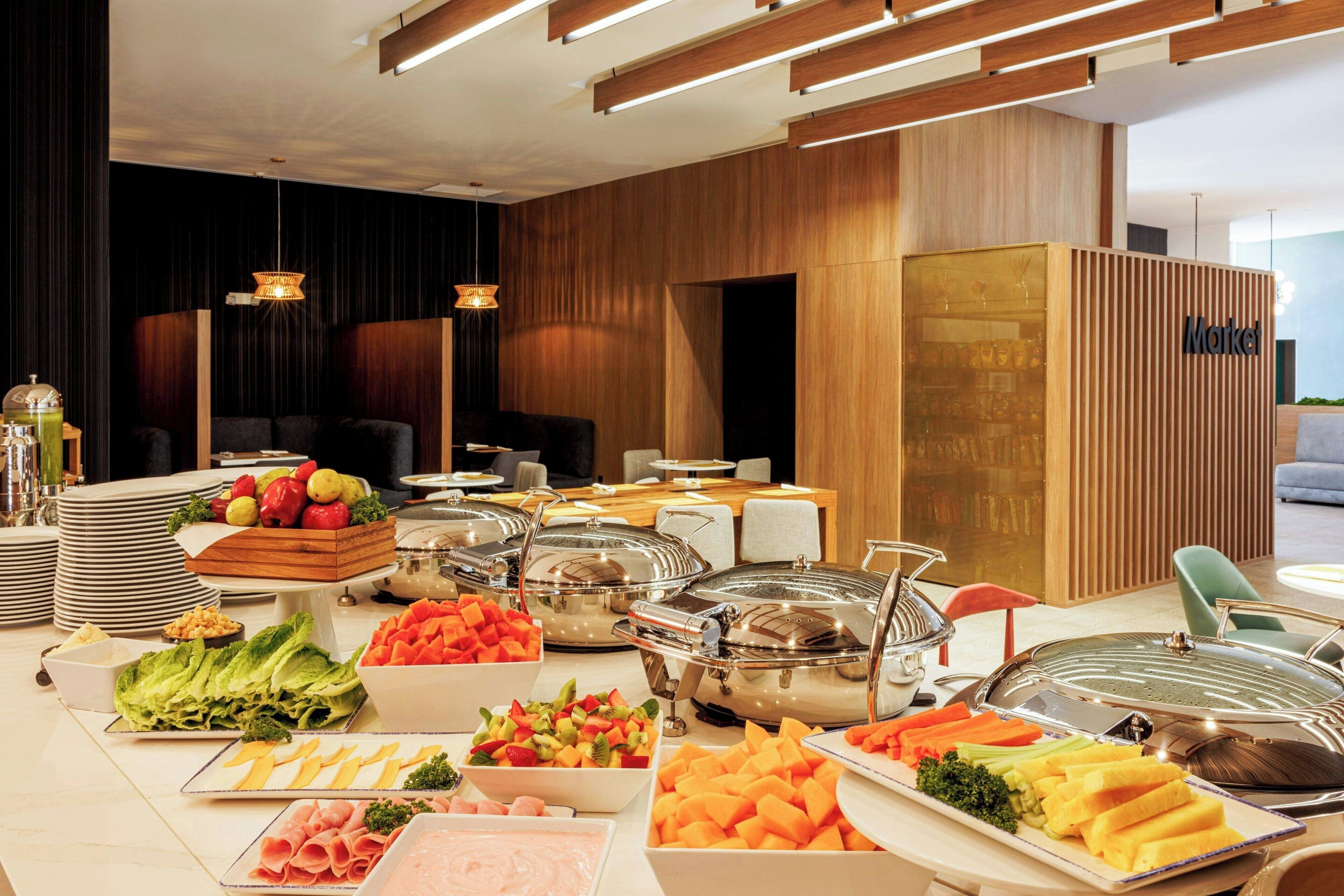 A buffet setup with various food items and a 'Market' sign in the background.