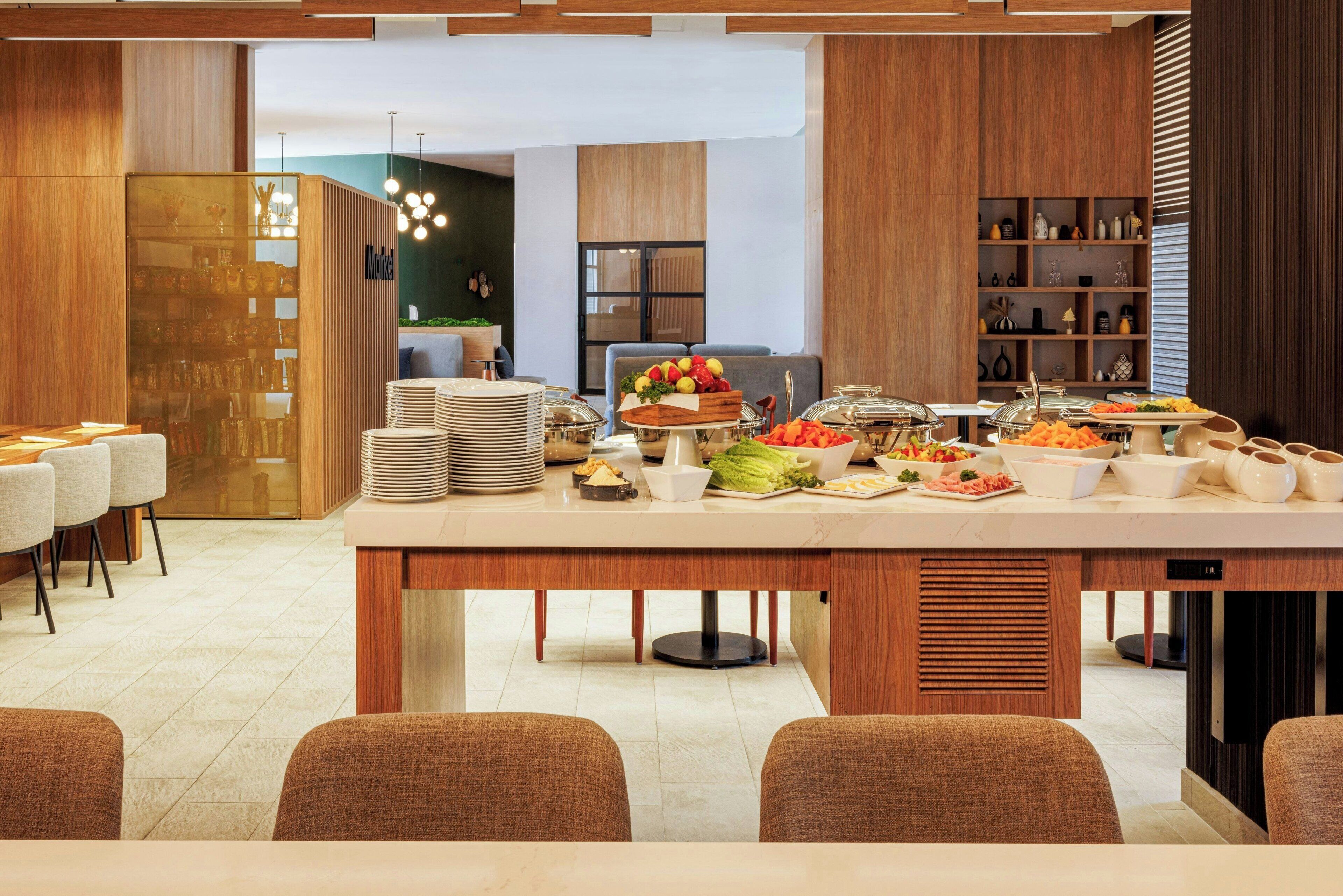 A buffet setup with various food items and a seating area with chairs.