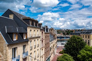 A row of historic buildings with a river in the background. - Dieppe: Unique Duplex in the City Center (Dieppe)