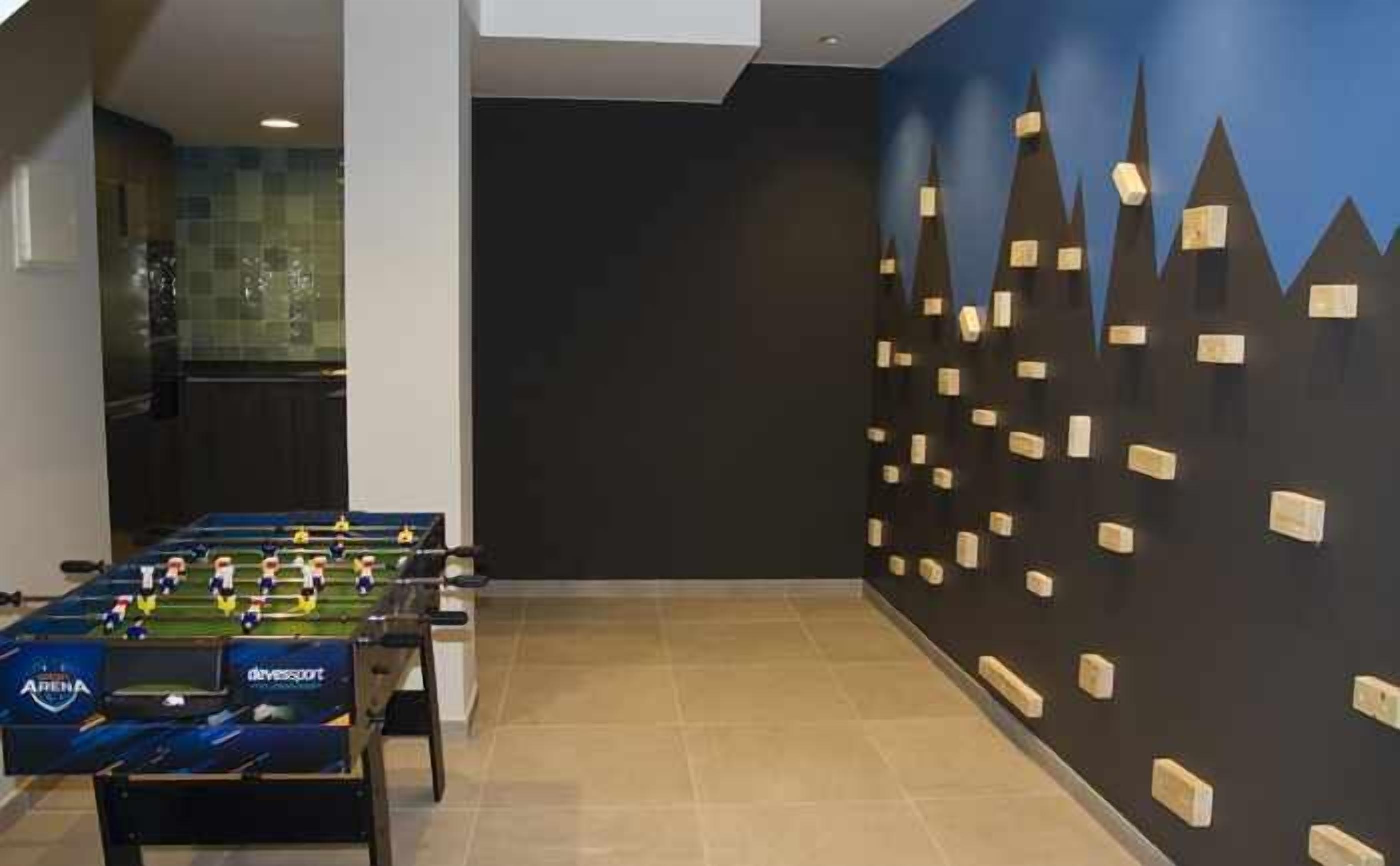 Una habitación con una mesa de fútbol de mesa y una pared con un diseño geométrico.