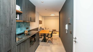 A modern kitchen with dark wood cabinets, a wooden countertop, and a dining area with a table and chairs. - Mocho-rural -home Adaptado (Beceite)