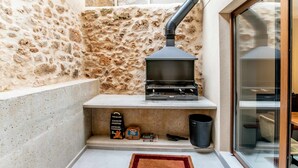Un mur en pierre avec une cheminée et une fenêtre.