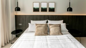 A modern hotel room with a large bed, two bedside tables, and three framed pictures on the wall. - Mocho- Rural- Home Villanueva A (Beceite)