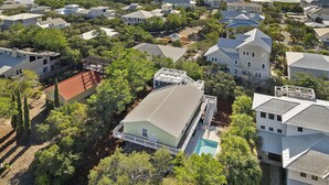 An aerial view of a coastal residential area with houses, a swimming pool, and a beach in the background. - Dune Betty - 30A, Heated Private Pool, Walk to the Beach + Restaurants! (Santa Rosa Beach)