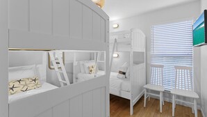 A room with bunk beds, a small table, and a window with blinds. - Dune Betty - 30A, Heated Private Pool, Walk to the Beach + Restaurants! (Santa Rosa Beach)