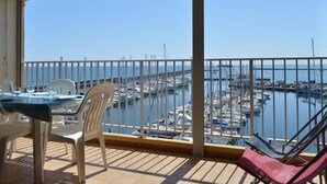 Un balcone con vista su un porto turistico e il mare.