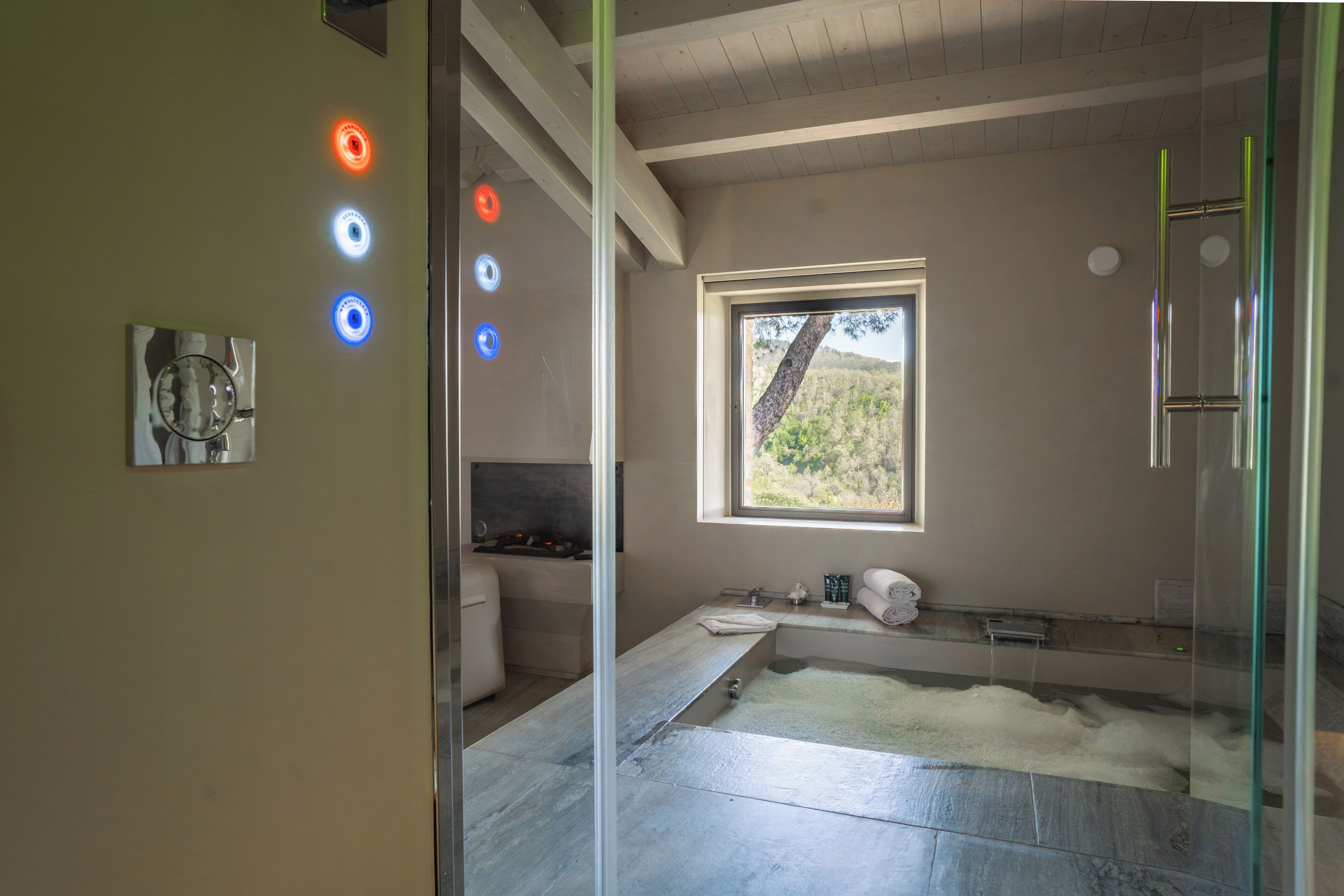 Un baño moderno con cabina de ducha de vidrio, un ventanal con vistas y una sauna integrada.