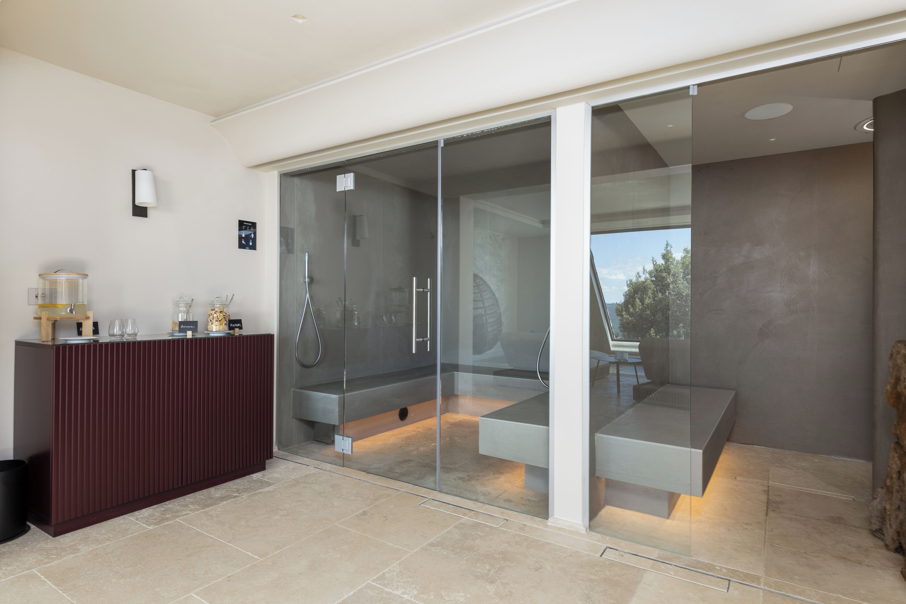 A modern bathroom with a glass shower enclosure, a wooden vanity, and a view of the outdoors.