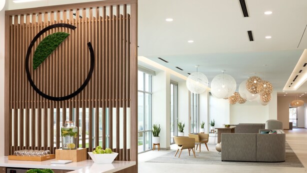 A modern reception area with a wooden partition, a glass display case with decorative items, and a seating area with contemporary furniture.