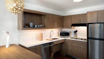 A modern kitchen with wooden cabinets, stainless steel appliances, and a white countertop.