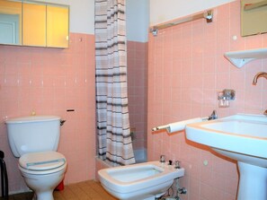 Een badkamer met toilet, bidet en wastafel.