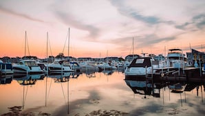 A marina with multiple boats docked at calm water reflecting the sky. - Pool, Outdoor living, 100 yards from Lake Michigan! (New Buffalo)