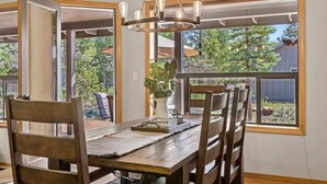 A dining area with a wooden table, chairs, and a chandelier. - AC, Hot Tub, One level, Pet friendly (Sunriver)