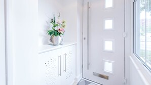 Une porte blanche avec une poignée et une petite fenêtre.