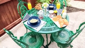 Une table en métal verte, sur laquelle se trouvent un ordinateur portable, des bols et des aliments.