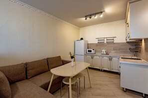 A compact kitchen with a dining area, a microwave, a refrigerator, and a sink. - Inndays Apartment on Annino 3 (Moscow)