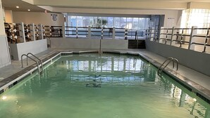 An indoor swimming pool with clear water, metal railings, and a tiled edge. - Family Friendly Fully Equipped two bedrooms two bathrooms Condo in garden city (Murrells Inlet)