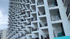 A high-rise building with multiple balconies and a modern architectural design. - Family Friendly Fully Equipped two bedrooms two bathrooms Condo in garden city (Murrells Inlet)