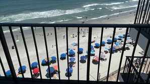 A beach with umbrellas and people. - Family Friendly Fully Equipped two bedrooms two bathrooms Condo in garden city (Murrells Inlet)