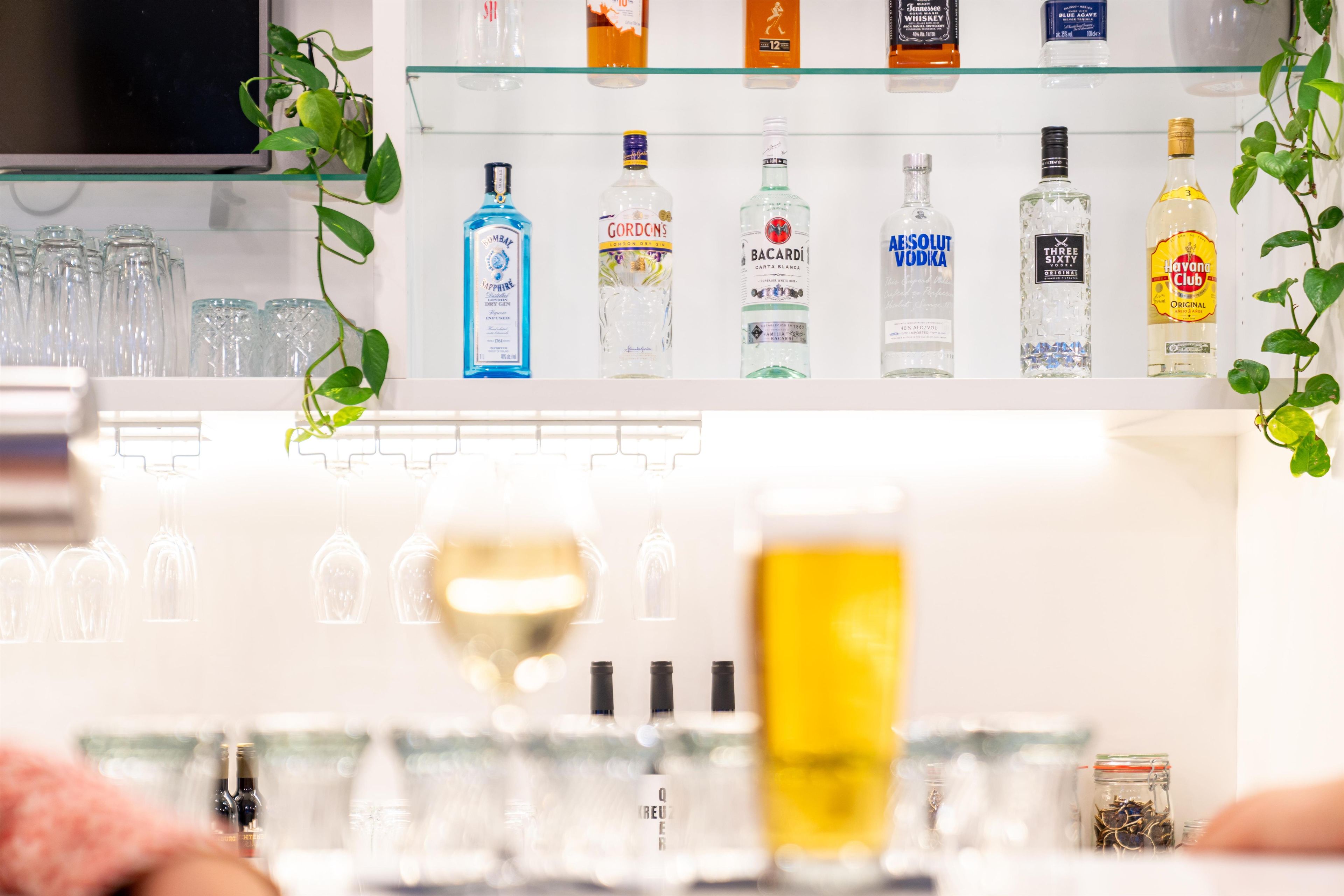 A bar area with various liquor bottles and glasses.