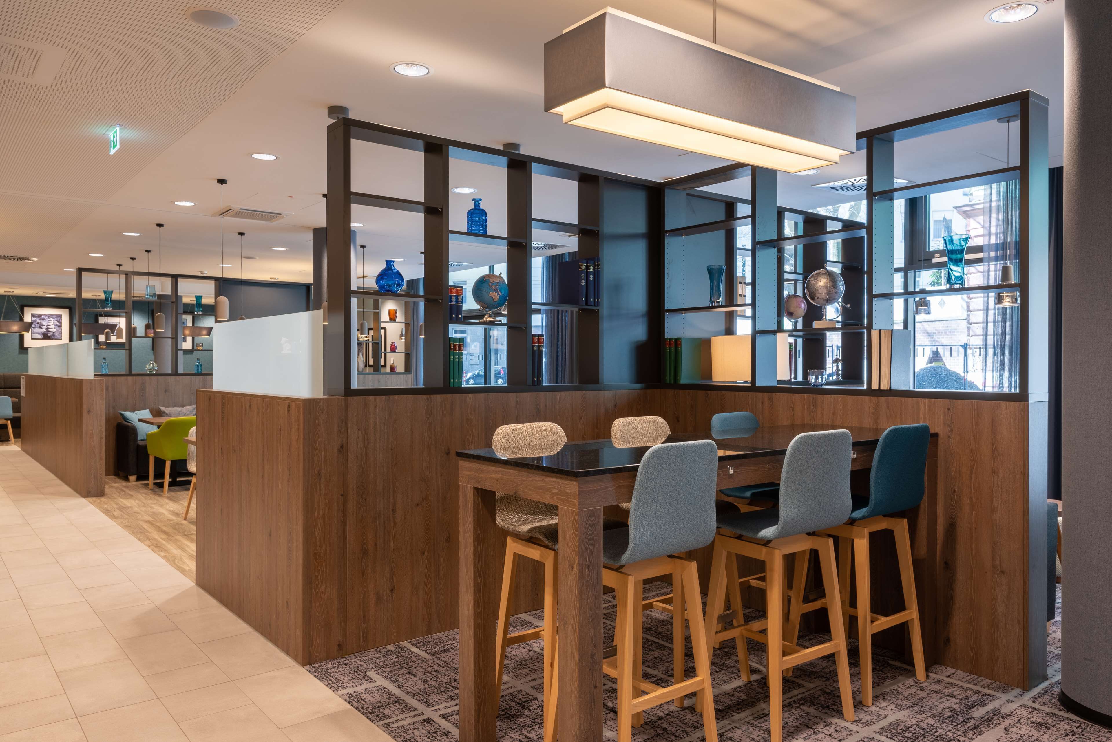 A modern interior with a wooden bar area, seating, and glass partitions.