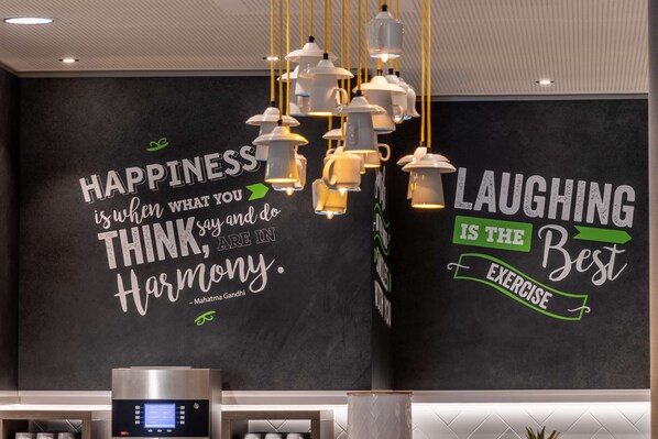 A wall with motivational quotes and a modern light fixture. - Hampton by Hilton Düsseldorf City Centre (Düsseldorf)