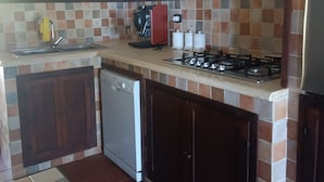 A compact kitchen with a dishwasher, a gas stove, and a coffee maker.