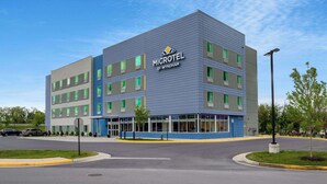 A modern Microtel hotel by Wyndham with a blue and gray exterior, multiple windows, and a parking lot. - Microtel Inn & Suites by Wyndham Winchester (Winchester)